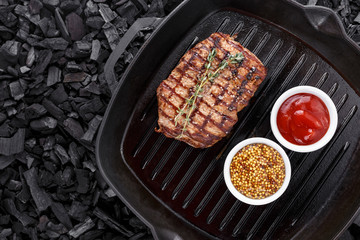 Grilled steak cooked in a frying pan.