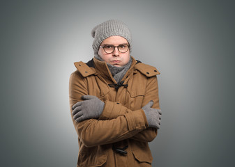 Handsome young boy freezing in warm clothing with copy space