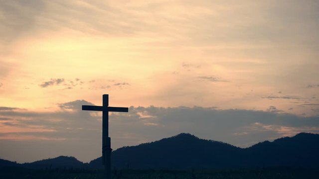 Conceptual wood cross or religion symbol shape over a sunset sky with clouds background for God. belief or resurrection of god and worship christian. Timelapse video 4k format.