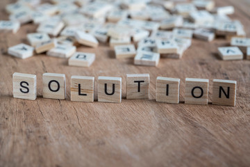 the word solution written with cube letters on wood background