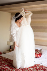 Fototapeta na wymiar Bride with beautiful manicure holding wedding dress. Wedding preparation of bride.