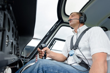 pilot in cockpit of helicopter during flight © auremar