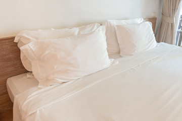 Fototapeta na wymiar Comfortable soft white pillows on the bed.