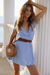 beautiful sensual woman with blond hair in elegant dress and accessories posing on the summer beach