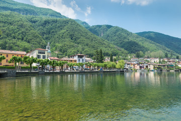 Fototapeta na wymiar Tourist town on the lake of Lugano; Riva San Vitale in summer, Switzerland, at the foot of Monte San Giorgio. Monte San Giorgio is a UNESCO site for the important fossiliferous deposits 
