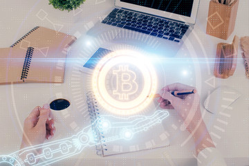 Cryptocurrency hologram over woman's hands writing background. Concept of blockchain. Multi exposure