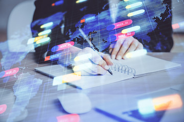 Double exposure of writing hands on background with data solution hologram on front. Technology concept. Close up