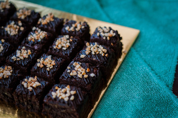Chocolate Cake Brownie Squares Drizzled With Chocolate Nutella and Walnuts. Closeup view, selective focus