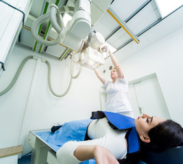 Radiologist and patient in a x-ray room. Classic ceiling-mounted x-ray system.