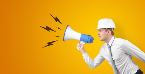 Fototapeta premium Young architect constructor yelling with megaphone and copyspace