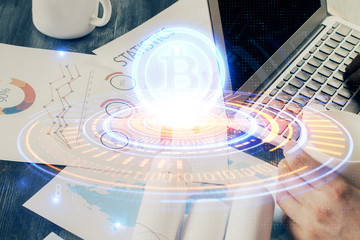 Crypto currency theme hologram with businessman working on computer on background. Concept of blockchain. Double exposure.