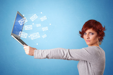 Woman holding laptop with online services symbols
