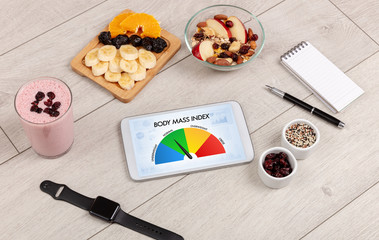 Healthy food with tablet on a wooden background with words Body Mass Index. Health concept.