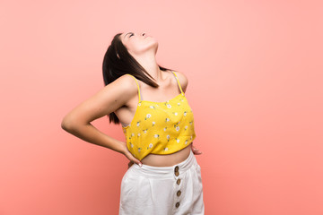 Young Mexican woman over isolated wall suffering from backache for having made an effort