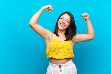 Young Mexican woman over isolated blue background celebrating a victory