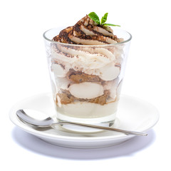 Classic tiramisu dessert in a glass on plate with spoon isolated on a white with clipping path