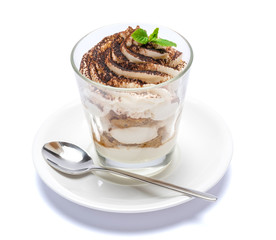 Classic tiramisu dessert in a glass on plate with spoon isolated on a white with clipping path