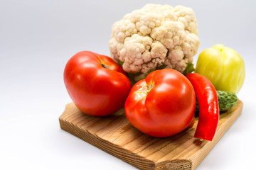 Fresh, bio,  garden growth vegetables on pine cutting board close up shot on gray background.