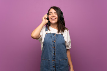 Young Mexican woman over isolated background listening to music with headphones