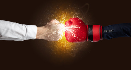 Two hands fighting with orange dust, spark, glow and smoke concept
