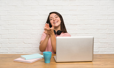 Young Mexican woman with a laptop applauding