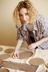 girl laying clay plates