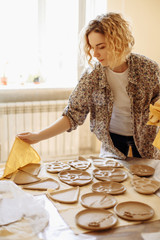 girl laying clay plates