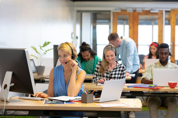 Customer service executives working at desk in a modern office