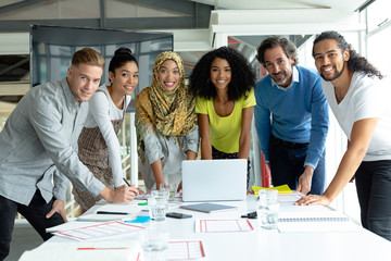 Business people looking at camera while working together at conference room in a modern office