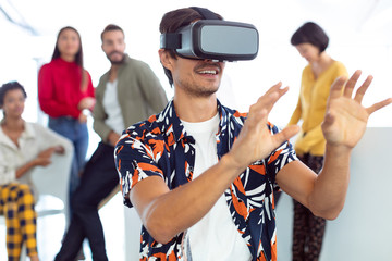 Young businessman using virtual reality headset in a modern office