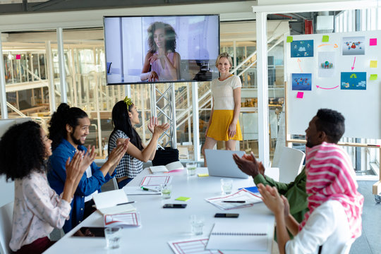 Business people applauding during video conference at conference room in a modern office