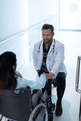 Male doctor consoling female patient in the corridor