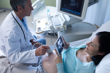 Naklejka na ściany i meble Doctor doing ultrasound scan for pregnant woman in hospital