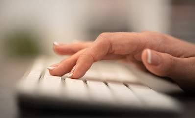 Hand typing on keyboard with office concept
