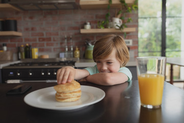 Boy having food at dining table at home