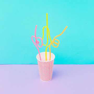 Paper cup of tasty summer cold beverage with colorful drinking straws.