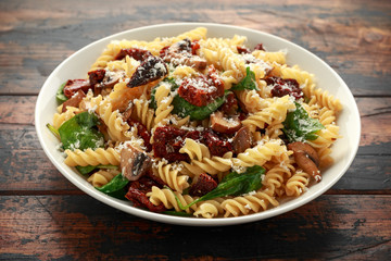 Fusilli Pasta with sun dried tomatoes, mushrooms, parmesan cheese and spinach. healthy food. - obrazy, fototapety, plakaty