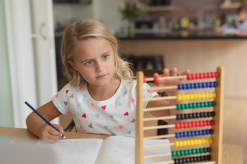 Girl doing homework at table in a comfortable home
