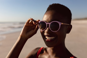 Woman in sunglasses standing on the beach