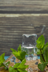 Ice cubes and mint leaves isolated on wooden cutting board