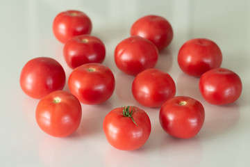 Fresh tomatoes on a white glass table. Harvesting tomatoes. Top view.