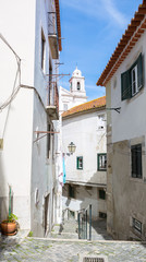 Typical narrow winding street in the Alfama district, Lisbon, Portugal.