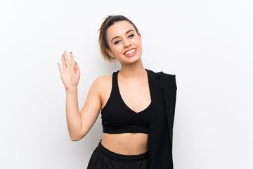Young sport woman over white wall saluting with hand with happy expression