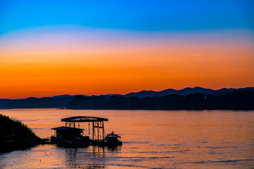 Fototapeta na wymiar Beautiful Silhouette Orange Sunset on the Lake Hill with Many Birds Flying.