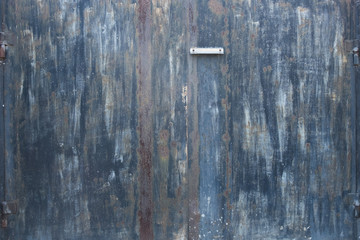 Background of old iron rusty gate. Gates with peeling paint. The texture of the old metal fence. Black gate with a slot for mail.