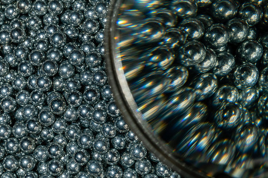 Split image of 3/16 inch ball bearings half at macro size and half through a magnafying glass in the same shot.