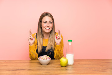 Young woman with bowl of cereals with fingers crossing