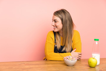 Young woman with bowl of cereals standing and looking to the side