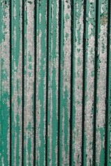 The background of the old estimated fence with shabby green paint. . Texture of metal wall with shabby old paint.