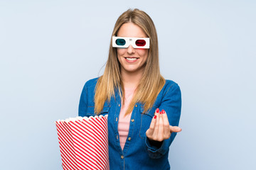 Blonde woman eating popcorns presenting and inviting to come